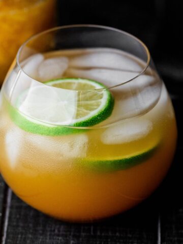 Mango shrub mocktail on a black background.